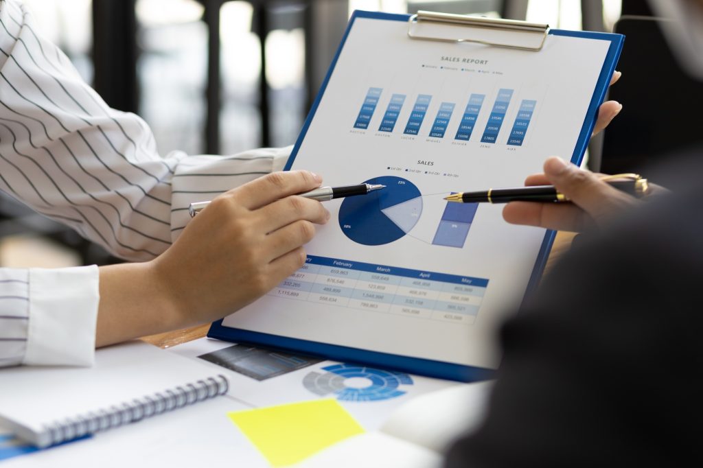 Business finance consultants discuss analysis of marketing reports profitability of the business.