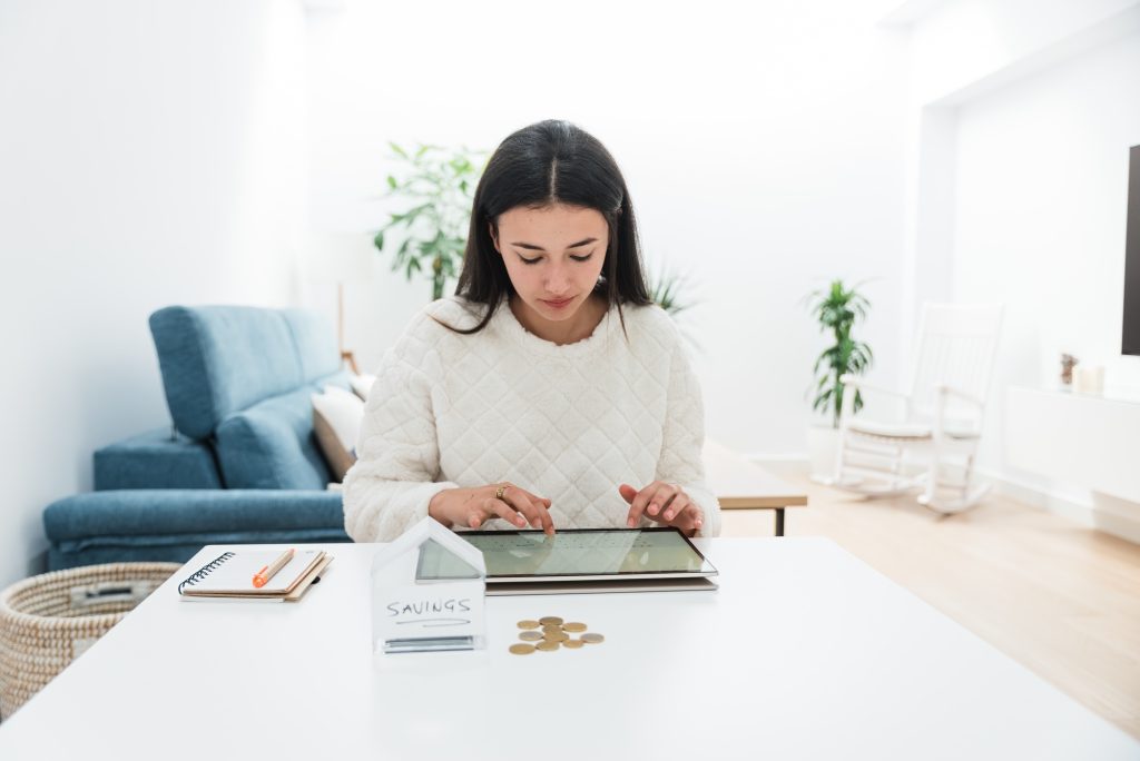 Young woman using tablet to manage savings