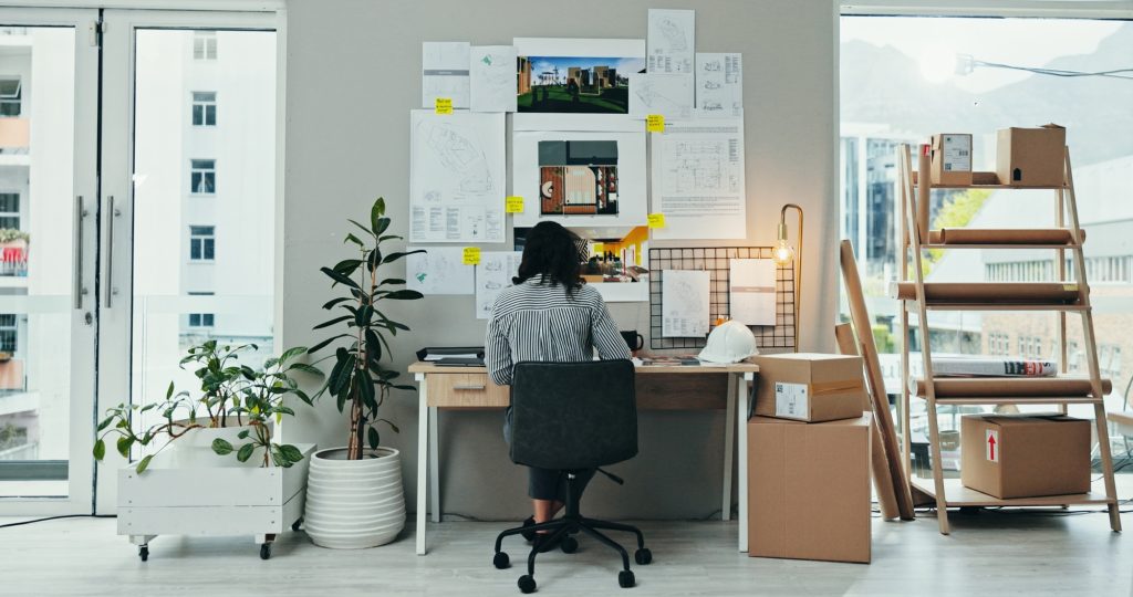 Back, woman or planning in office for architecture, design process or blueprint for housing develop