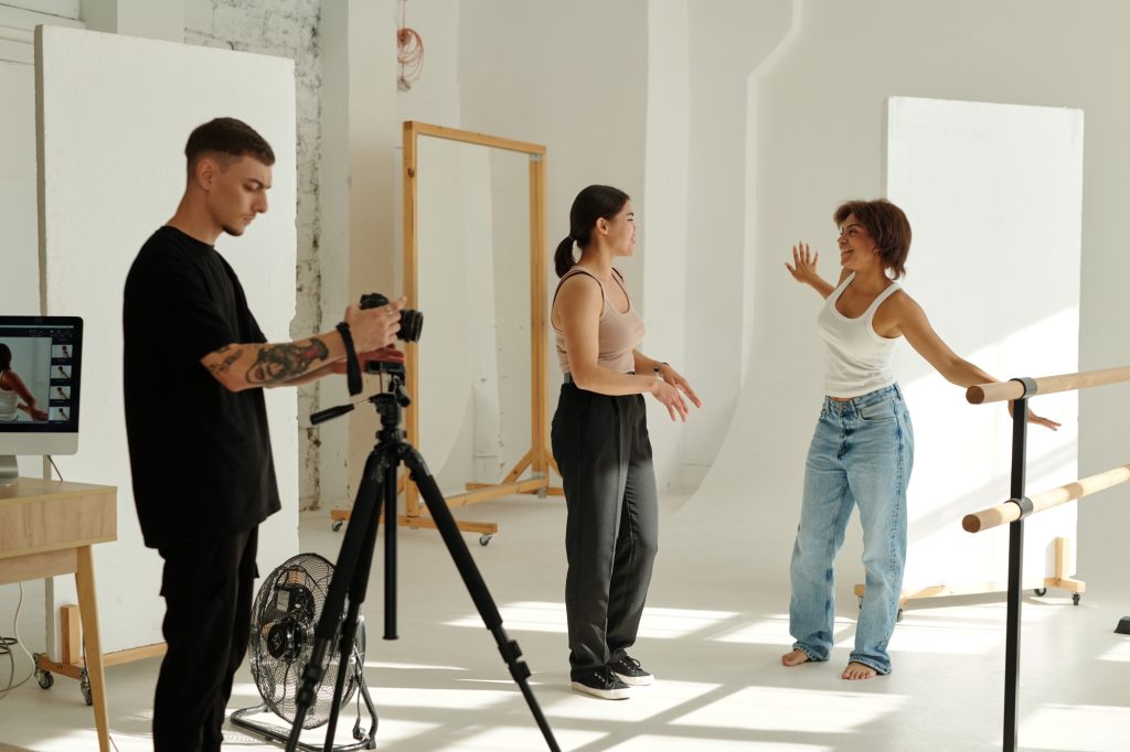 Two happy intercultural women discussing poses before photo session