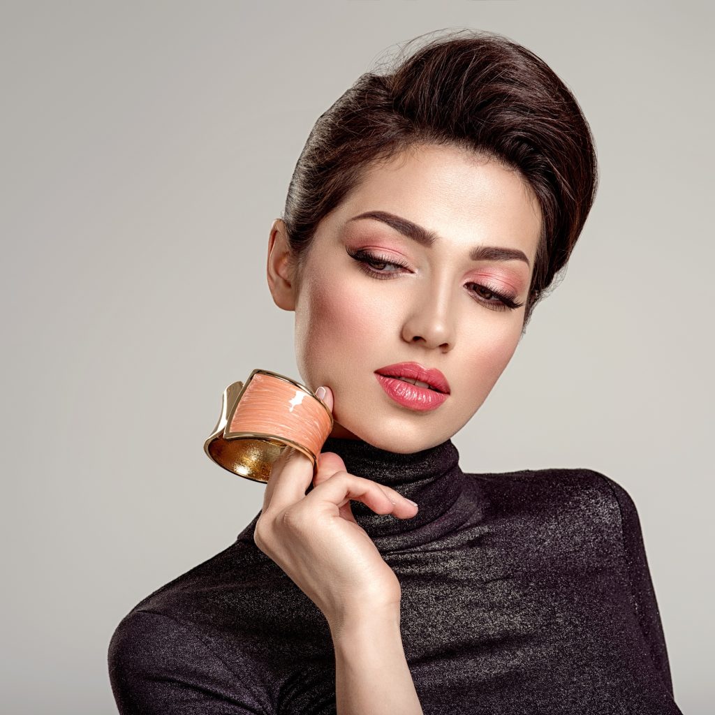 Beautiful fashion woman with living coral lipstick. Attractive white girl wears luxury jewelry.