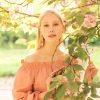 Gorgeous female model having fun in blooming Paris garden.