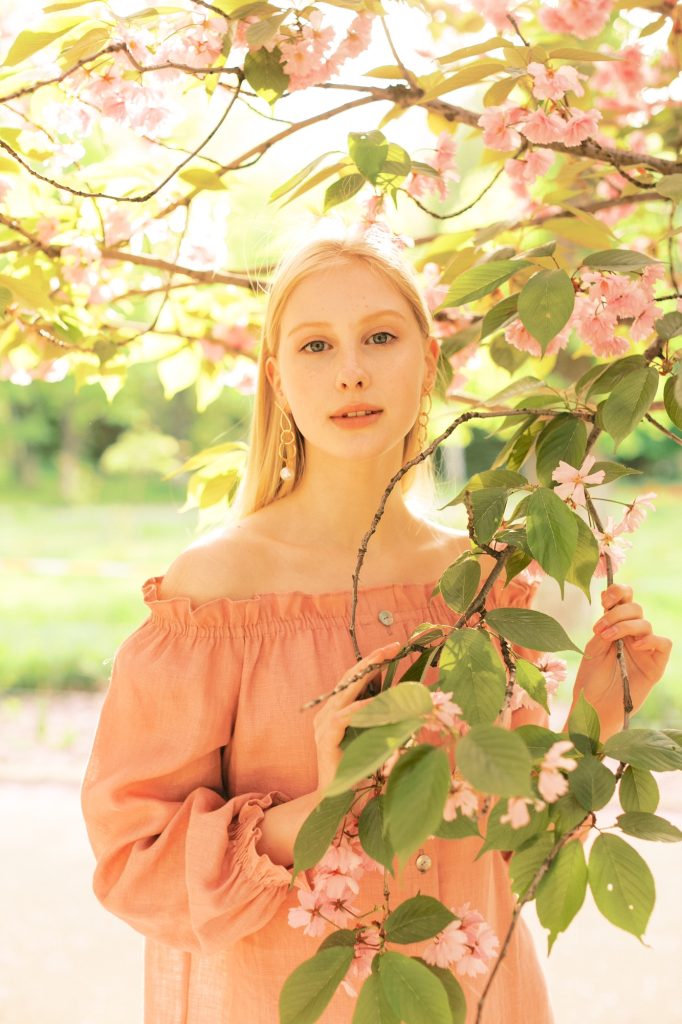 Gorgeous female model having fun in blooming Paris garden.